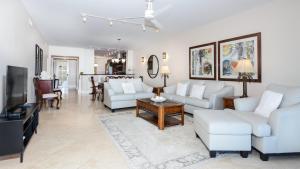 a living room with white furniture and a tv at 122 Mariners Club in Key Largo