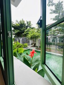 a window view of a swimming pool from a house at PhuQuoc Homestay in Long Bình
