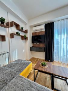 a living room with a couch and a tv at Emerald Luxury Apartments in Skopje