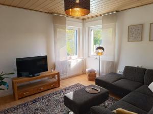 a living room with a couch and a flat screen tv at Ferienwohnung am Kurwald, Nähe Kliniken, 88qm, Parkplatz in Bad Lippspringe