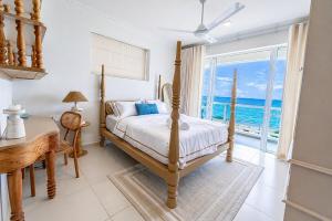 a bedroom with a bed and a desk and a window at Anarma Oceanfront Apartment in Wattala +23 photos