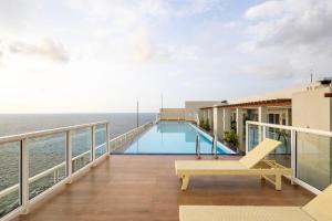 a balcony with a swimming pool and the ocean at Anarma Oceanfront Apartment in Wattala