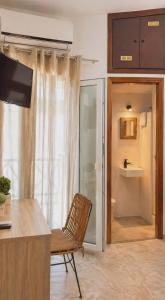 a kitchen with a chair and a sliding glass door at Diana in Ermoupoli