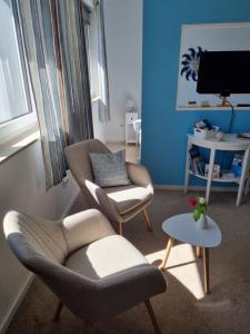 a living room with two chairs and a table at Auszeit am Rosengarten, Zentrumsnah in Güstrow