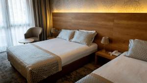 a hotel room with two beds and a chair at Yoncalı Termal Spa Otel in Ortaca