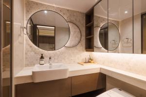 a bathroom with a sink and two mirrors at Seoul Modern Cozy Stay in Seoul +38 photos