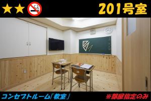 a classroom with two desks and a chalkboard at HOTEL Us Racecourse Adult only in Niigata