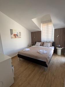 a bedroom with a large bed and a window at Apartmani M&L in Medulin