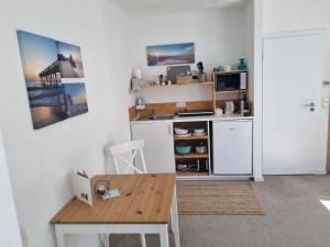 a small kitchen with a table and a microwave at Auszeit am Rosengarten, Zentrumsnah in Güstrow +10 photos