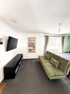 a living room with a couch and a bed at Princess House in Redhill