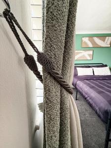 a curtain is tied to a window in a bedroom at Princess House in Redhill