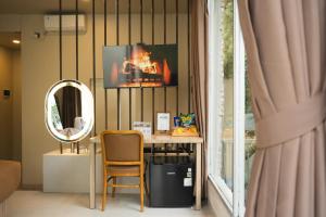 a room with a desk with a mirror and a chair at HeHa Waterfall Suites & Camping Ground in Paragajen