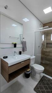 a white bathroom with a sink and a toilet at Residencial Felicita in Barueri