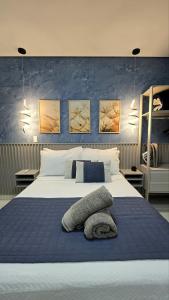 a bedroom with a large bed with a blue wall at Residencial Felicita in Barueri