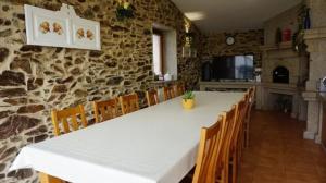 a dining room with a white table and chairs at Casa Os Lindeiros in Arzúa