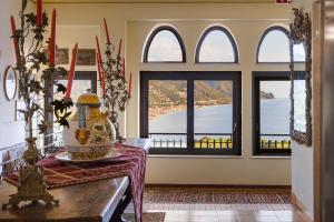 a room with windows and a table with a vase on it at Hotel Sirius in Taormina