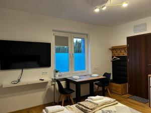 a living room with a table and a large flat screen tv at Hello Tu Modlin in Zakroczym