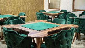a conference room with wooden tables and green chairs at Yoncalı Termal Spa Otel in Ortaca