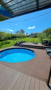a large blue swimming pool on a wooden deck at Casa 3 Catei Veseli in Seciu