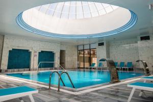 a large swimming pool in a building with a domed ceiling at Yoncalı Termal Spa Otel in Ortaca