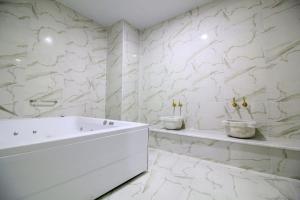 a white bathroom with a tub and two sinks at Yoncalı Termal Spa Otel in Ortaca +23 photos