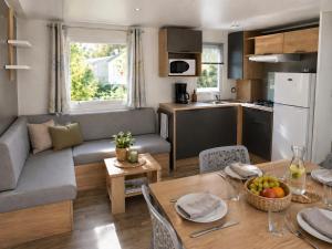 a kitchen and living room with a table and a couch at Camping de la Baie-Baie de Somme-Sites et Paysages in Pendé