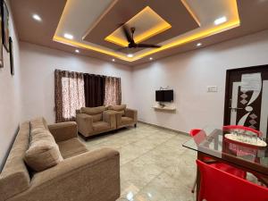 a living room with a couch and a tv at Crescent Holiday Homes in Panchgani