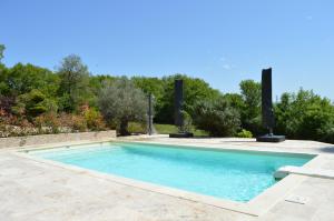 a swimming pool with blue water in a yard at La Tourelle du Lot in Cajarc