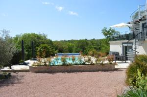 a garden with white flowers in front of a building at La Tourelle du Lot in Cajarc