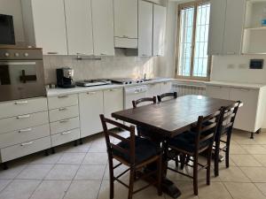 a kitchen with a wooden table and chairs in it at Affittacamere VITRUVIO in Fano
