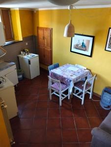 a kitchen with a table and chairs in a room at Appartamento Rosa in Montale