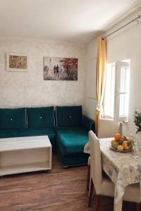 a living room with a green couch and a table at Stone Garden Residence in Budva