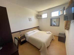 ein Schlafzimmer mit einem Bett und zwei Fenstern in der Unterkunft Albergo Perseo in Portopalo