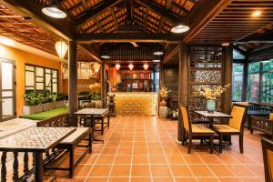 a restaurant with tables and chairs in a room at Nova Vista Villa Hoi An in An Bàn (2)