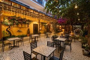an outdoor patio with tables and chairs and lights at Nova Vista Villa Hoi An in An Bàn (2)