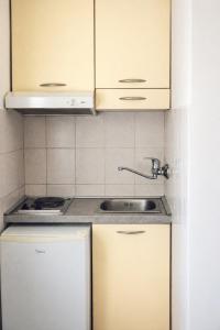 a kitchen with white cabinets and a sink at Stone Garden Residence in Budva +34 photos
