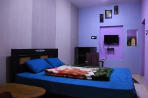 a bedroom with a blue bed and a table at Pinetree Stay in Kodaikānāl +12 photos