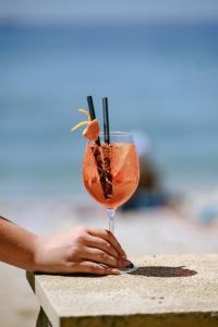 a woman holding a cocktail on a table at Bottega in Mlini