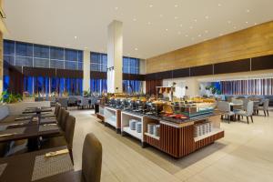 a restaurant with a buffet with tables and chairs at Amandaru Hotel Pekalongan in Pekalongan