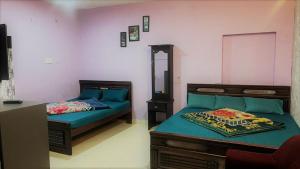 a bedroom with two beds and a mirror in it at Pinetree Stay in Kodaikānāl