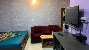 a room with a couch and a tv and a chair at Pinetree Stay in Kodaikānāl