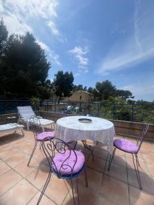 a table and chairs with purple cushions on a patio at La Panouse in Marseille