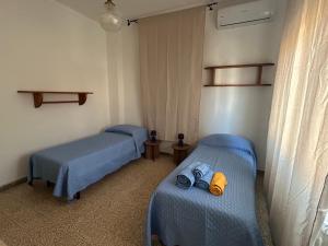 two beds in a room with shoes on them at Affittacamere VITRUVIO in Fano +13 photos