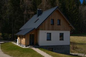 a small house with a gambrel roof and a garage at Chata Špička in Smržovka
