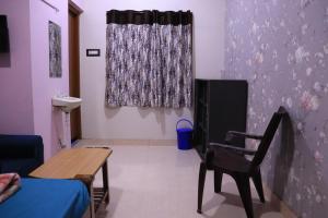 a room with a table and a chair and a window at Pinetree Stay in Kodaikānāl