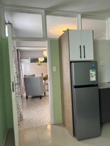 a kitchen with a refrigerator and a living room at 112 On Park Drive in Gqeberha
