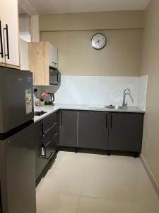 a kitchen with a sink and a clock on the wall at 112 On Park Drive in Gqeberha