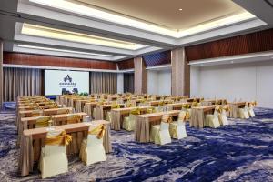 a conference room with tables and chairs and a screen at Amandaru Hotel Pekalongan in Pekalongan +33 photos