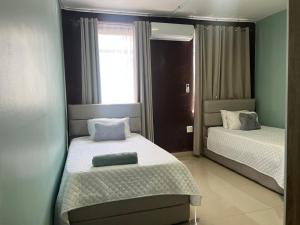 a bedroom with two beds and a window at 112 On Park Drive in Gqeberha