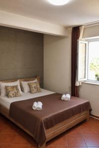 a bedroom with a large bed with towels on it at Stone Garden Residence in Budva